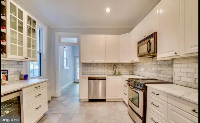 a kitchen with granite countertop cabinets stainless steel appliances a sink and a counter top space