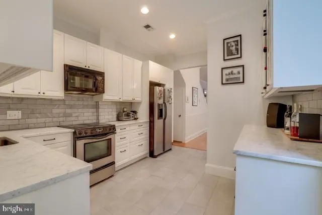 a kitchen with stainless steel appliances granite countertop a refrigerator stove and sink