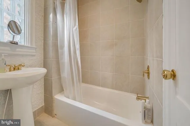 a bath tub sitting next to a white sink and a shower