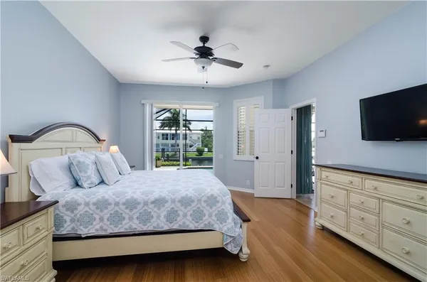 a bedroom with a large bed and a flat tv screen on dresser