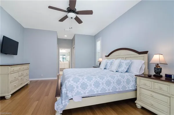 a bedroom with a bed and a flat tv screen on dresser