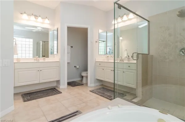 a spacious bathroom with a shower sink and mirror