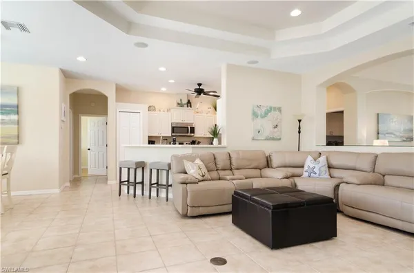a living room with furniture and a view of kitchen
