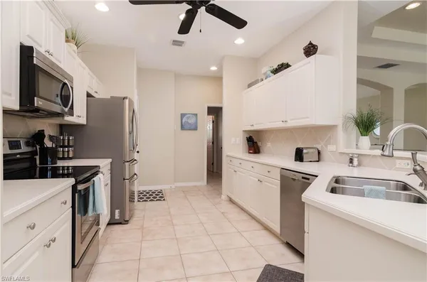 a kitchen with stainless steel appliances a refrigerator sink and microwave