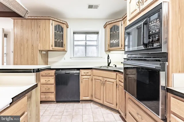 a kitchen with granite countertop a stove a sink and a refrigerator