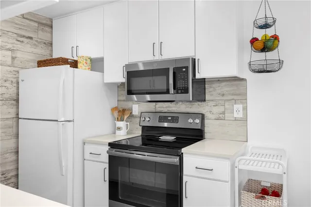 a kitchen with a refrigerator and a stove top oven