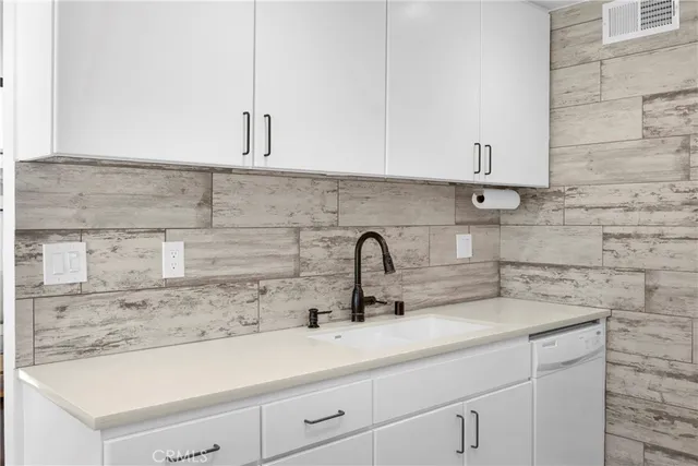 a kitchen with stainless steel appliances a sink stove and wooden floor