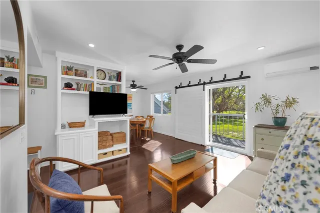a living room with furniture a flat screen tv and a large window