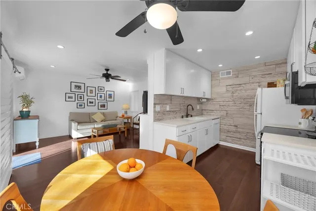 a kitchen with a sink appliances cabinets and dining table