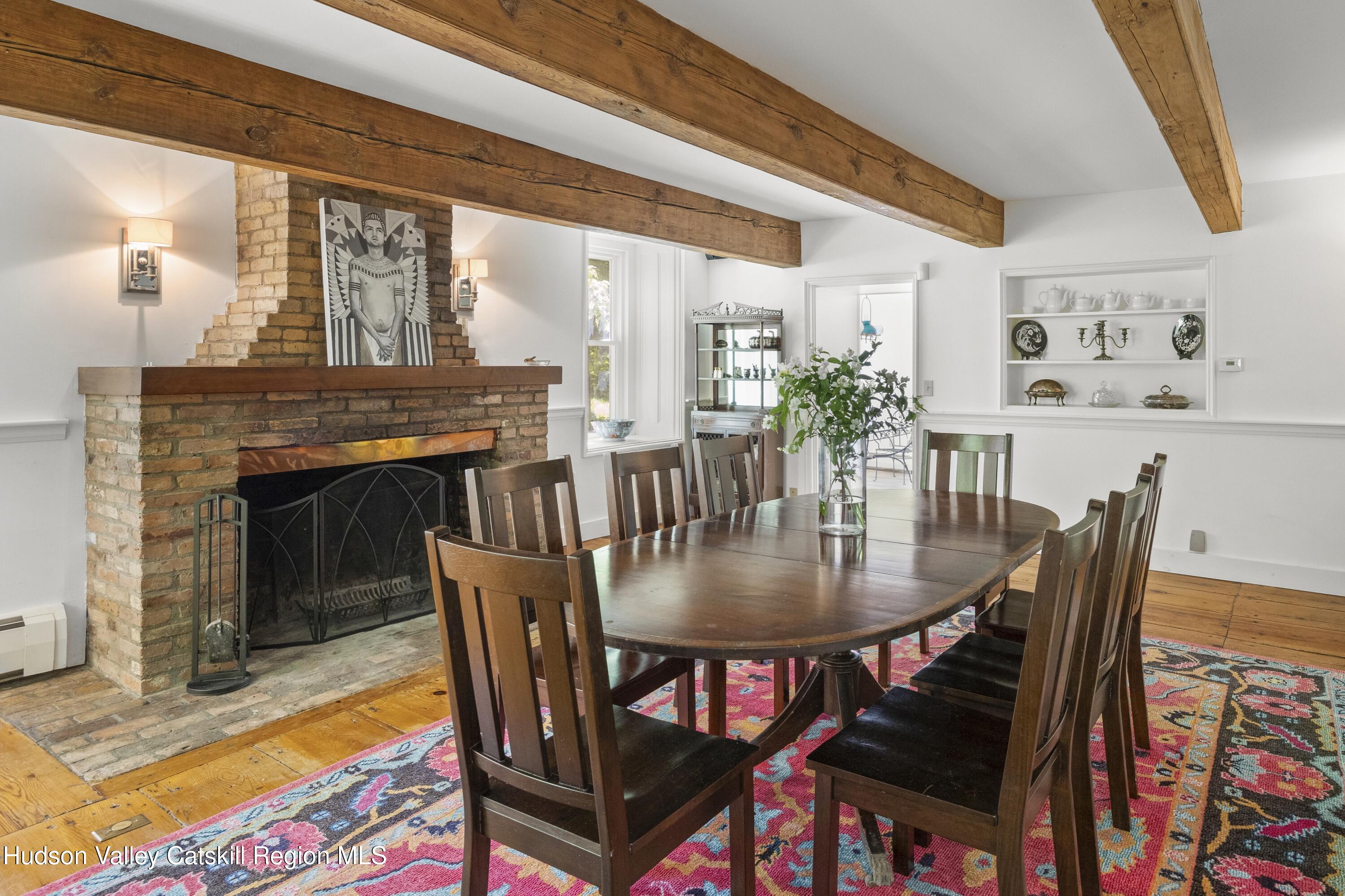 202 Buckwheat Bridge Road Germantown, NY 12526 - Photo 10 of 47 a dining room with furniture a rug a fireplace and a chandelier