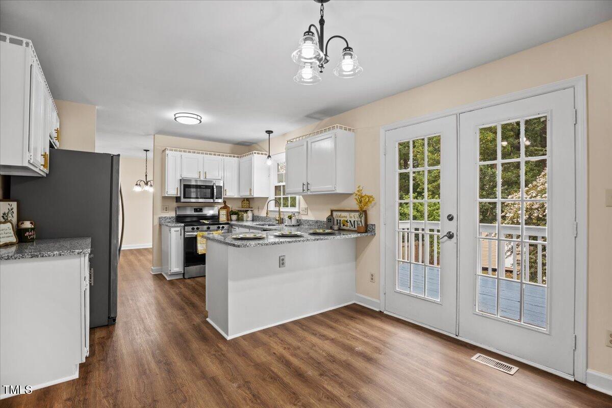 4309 Birmingham Way Raleigh, NC 27604 - Photo 11 of 60 a kitchen with a refrigerator a stove cabinets and wooden floor
