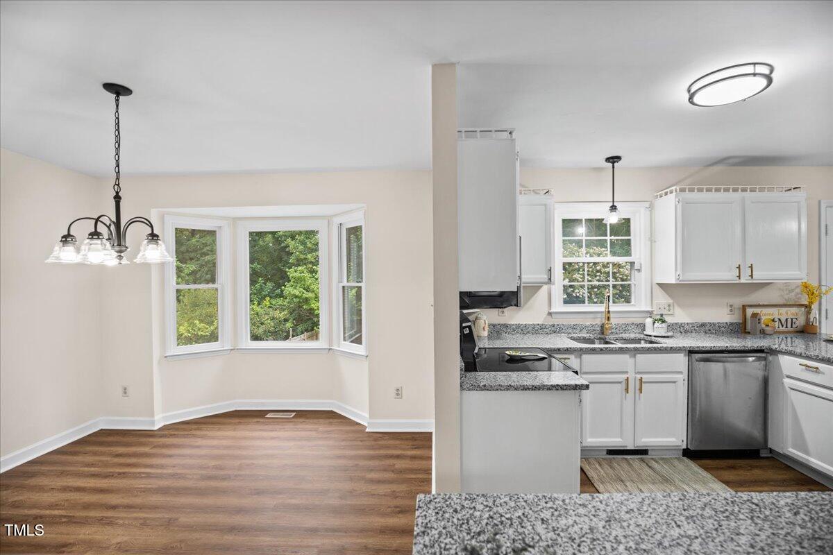4309 Birmingham Way Raleigh, NC 27604 - Photo 18 of 60 a kitchen with granite countertop a stove a sink and a window