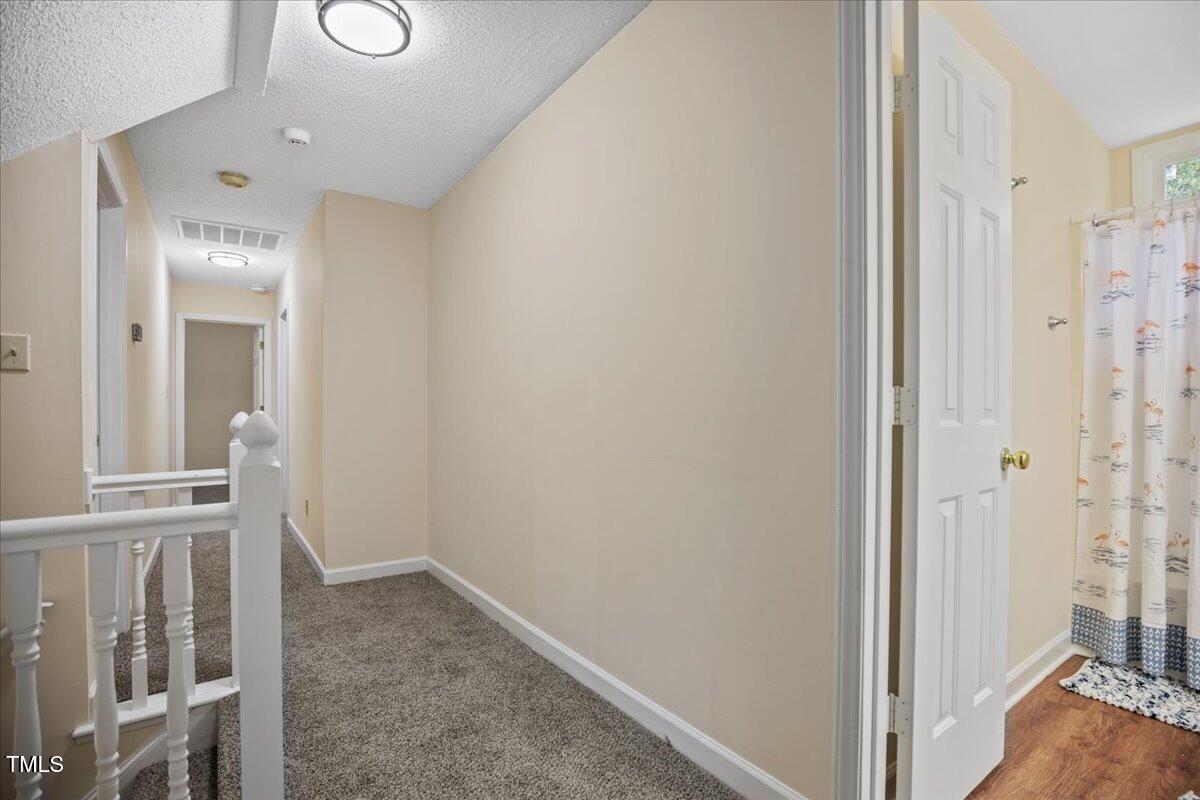 4309 Birmingham Way Raleigh, NC 27604 - Photo 23 of 60 a view of a hallway with a livingroom with wooden floor