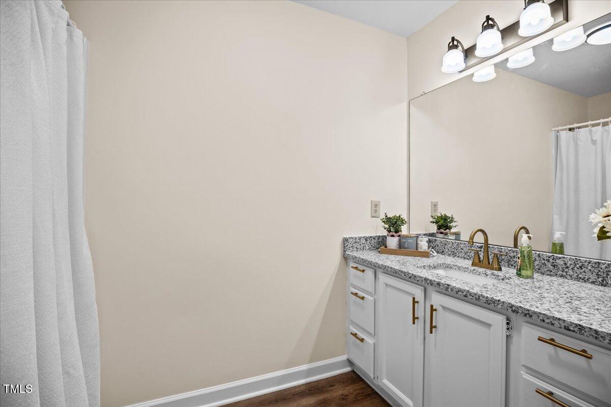 4309 Birmingham Way Raleigh, NC 27604 - Photo 38 of 60 a bathroom with a granite countertop sink and a mirror