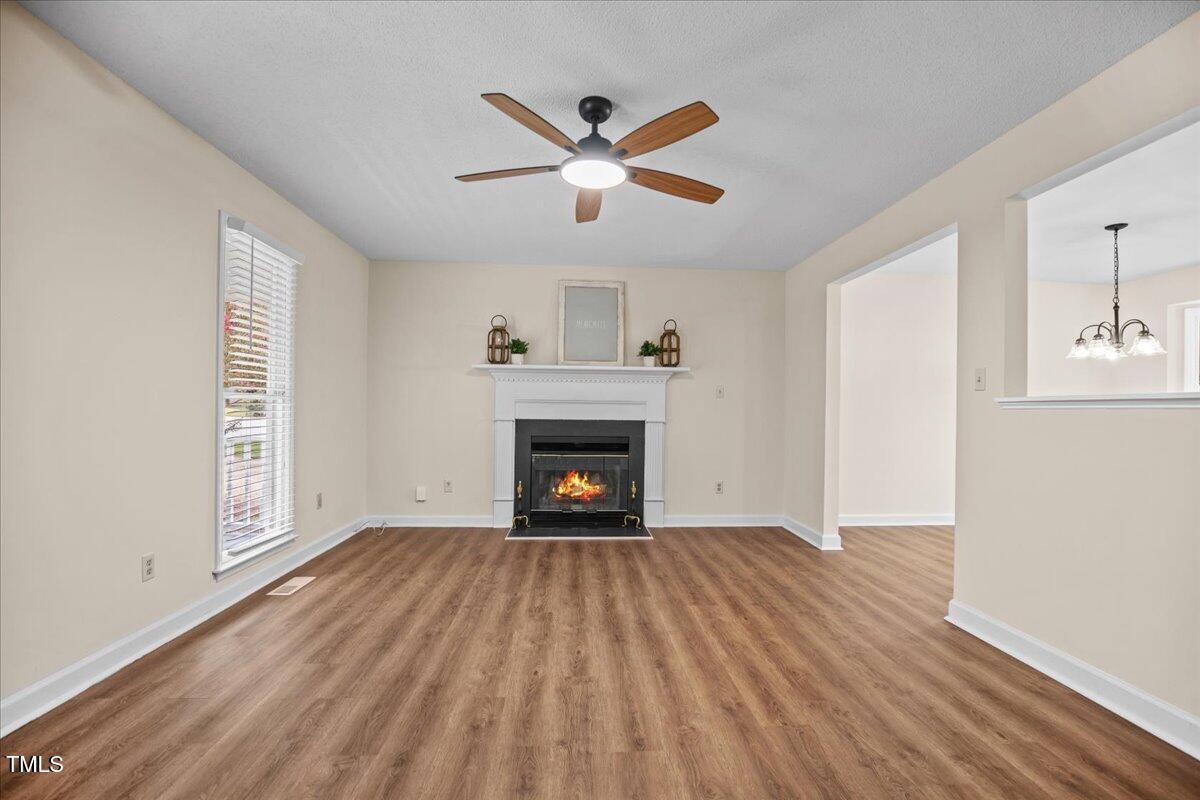 4309 Birmingham Way Raleigh, NC 27604 - Photo 7 of 60 a view of an empty room with wooden floor fireplace and a window