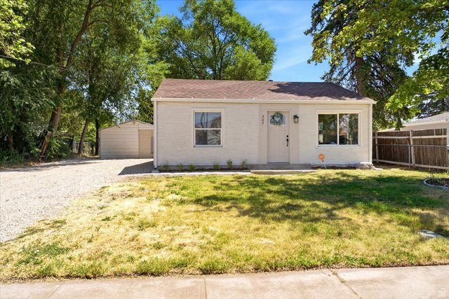 307 Flint Street Layton, UT 84041 - Photo 1 of 13 Single-story residence featuring a light-colored exterior, brown roof shingles, and a front entry with an overhead fixture