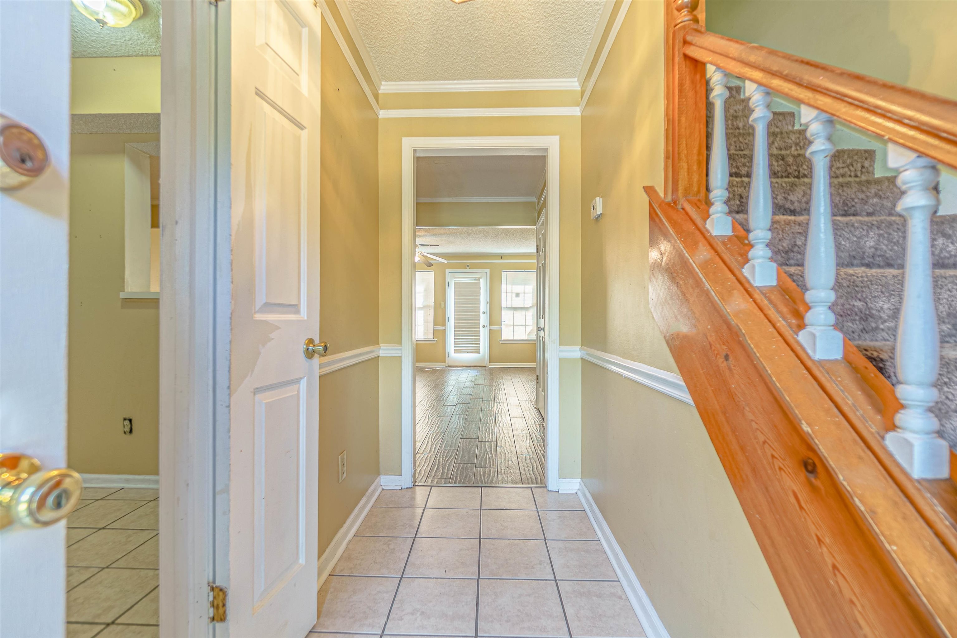 5891 Ridgehill Drive Memphis, TN 38141 - Photo 3 of 13 Corridor featuring a textured ceiling, crown molding, and light hardwood / wood-style floors