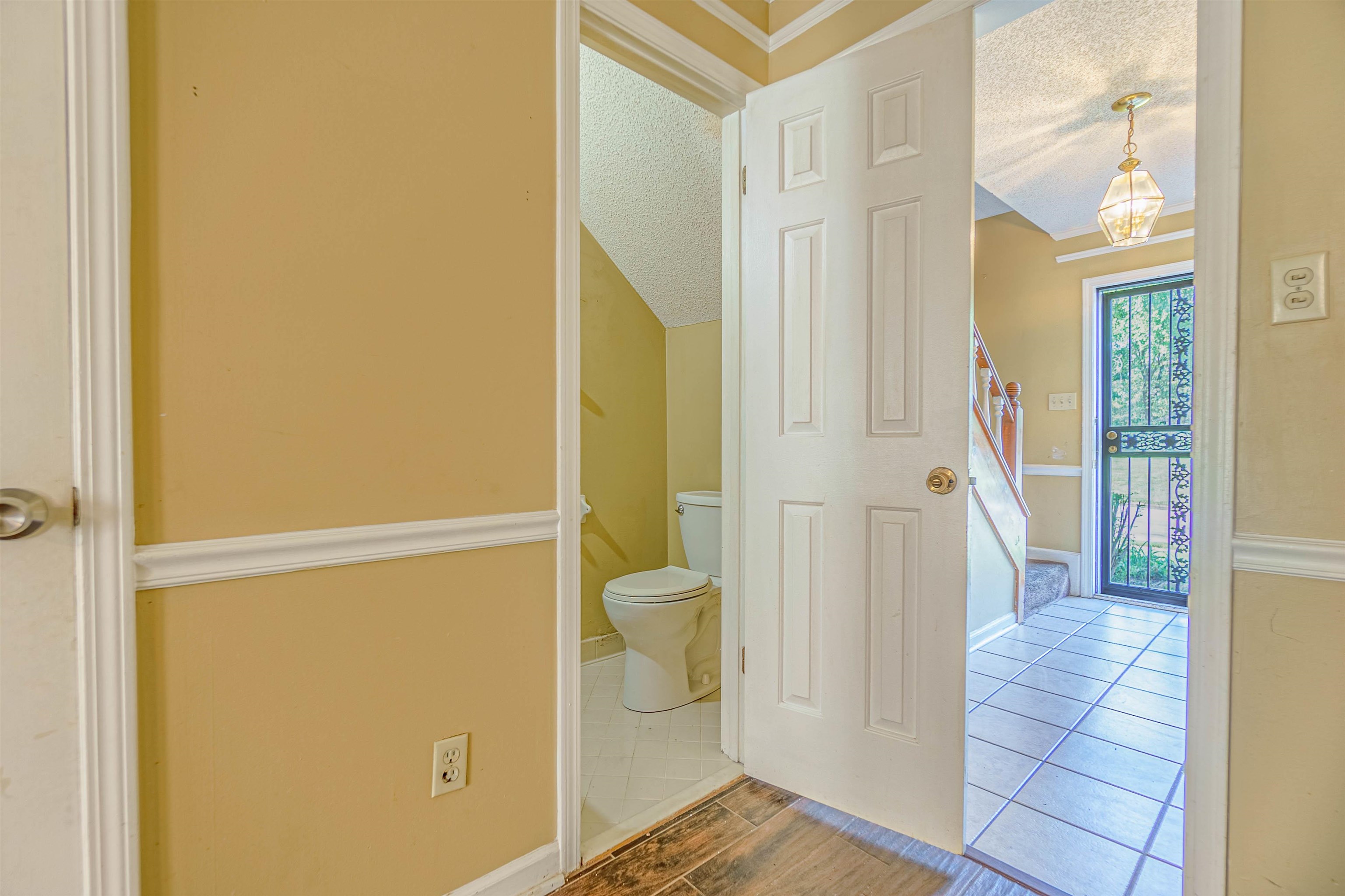 5891 Ridgehill Drive Memphis, TN 38141 - Photo 4 of 13 Bathroom with a notable chandelier, a textured ceiling, toilet, and tile patterned floors