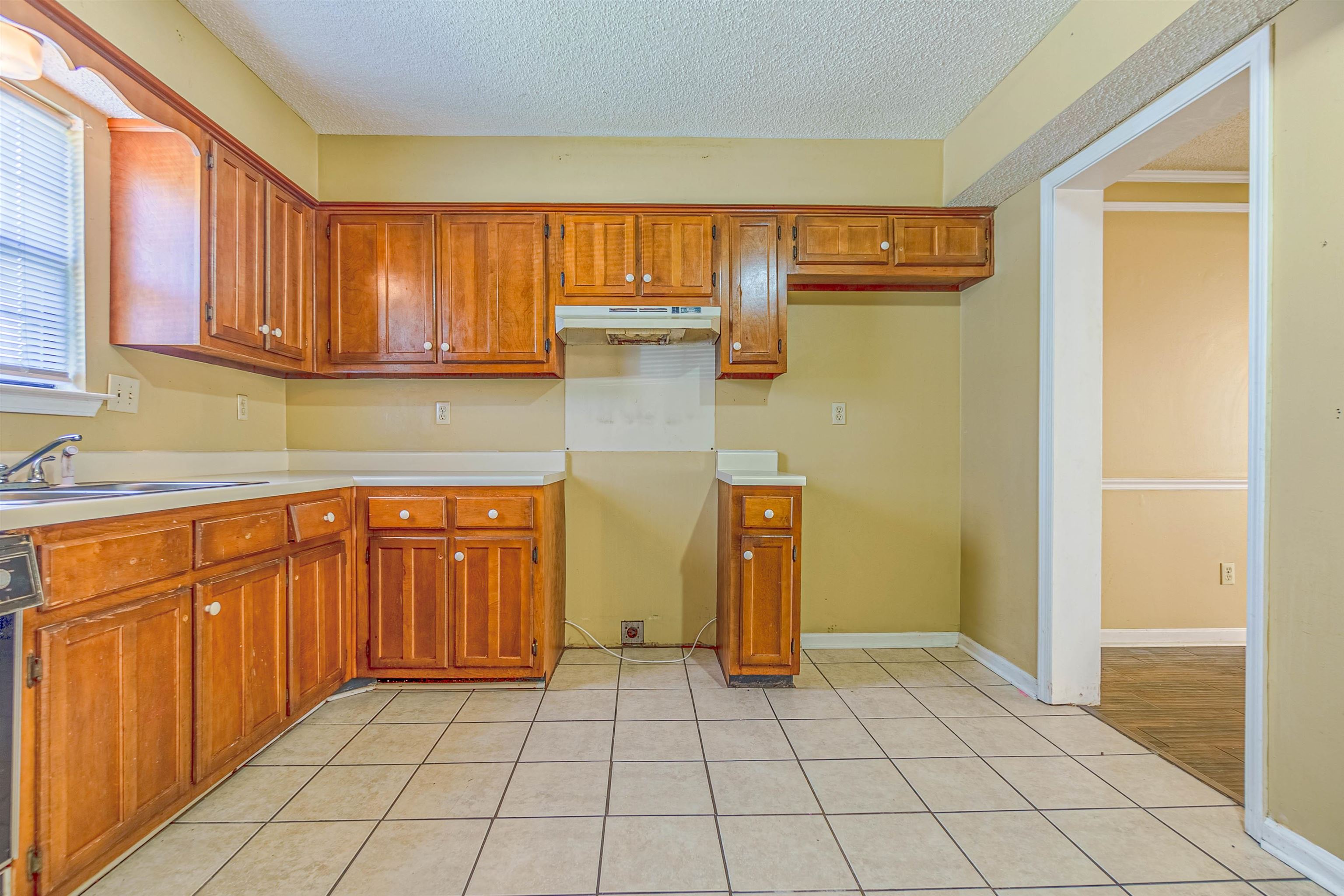 5891 Ridgehill Drive Memphis, TN 38141 - Photo 6 of 13 Kitchen with ornamental molding, a textured ceiling, light tile patterned floors, and dishwashing machine