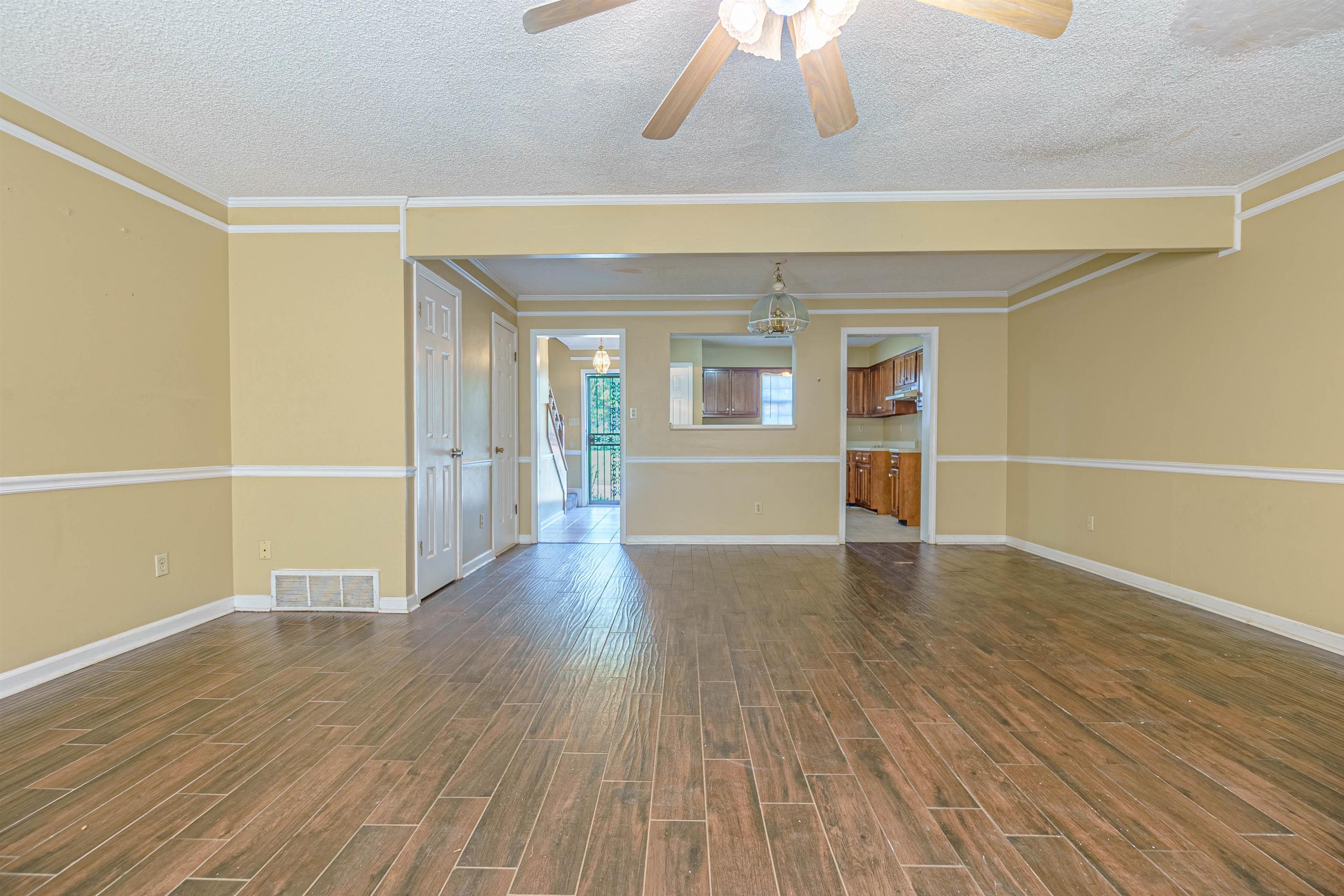 5891 Ridgehill Drive Memphis, TN 38141 - Photo 8 of 13 Unfurnished room featuring ornamental molding, a textured ceiling, ceiling fan with notable chandelier, and dark hardwood / wood-style flooring