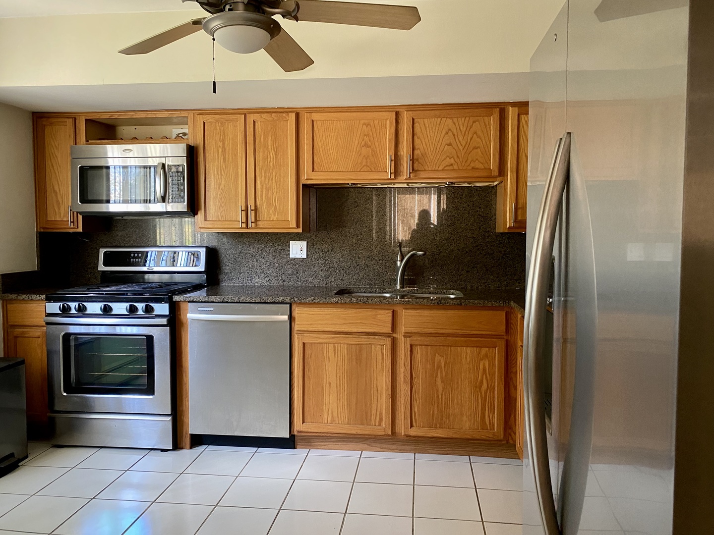 19398 Wolf Road, Unit 3 Mokena, IL 60448 - Photo 3 of 7 a kitchen with stainless steel appliances granite countertop a refrigerator a sink and a stove