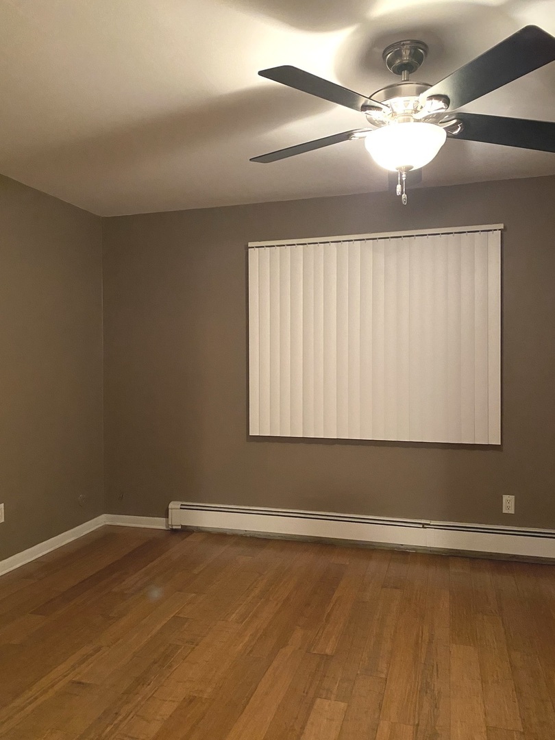 19398 Wolf Road, Unit 3 Mokena, IL 60448 - Photo 7 of 7 a view of a room with wooden floor and fan