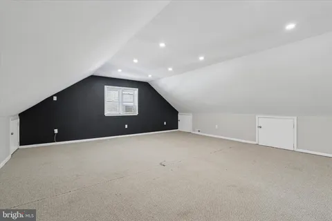 a view of an empty room with a window and fireplace