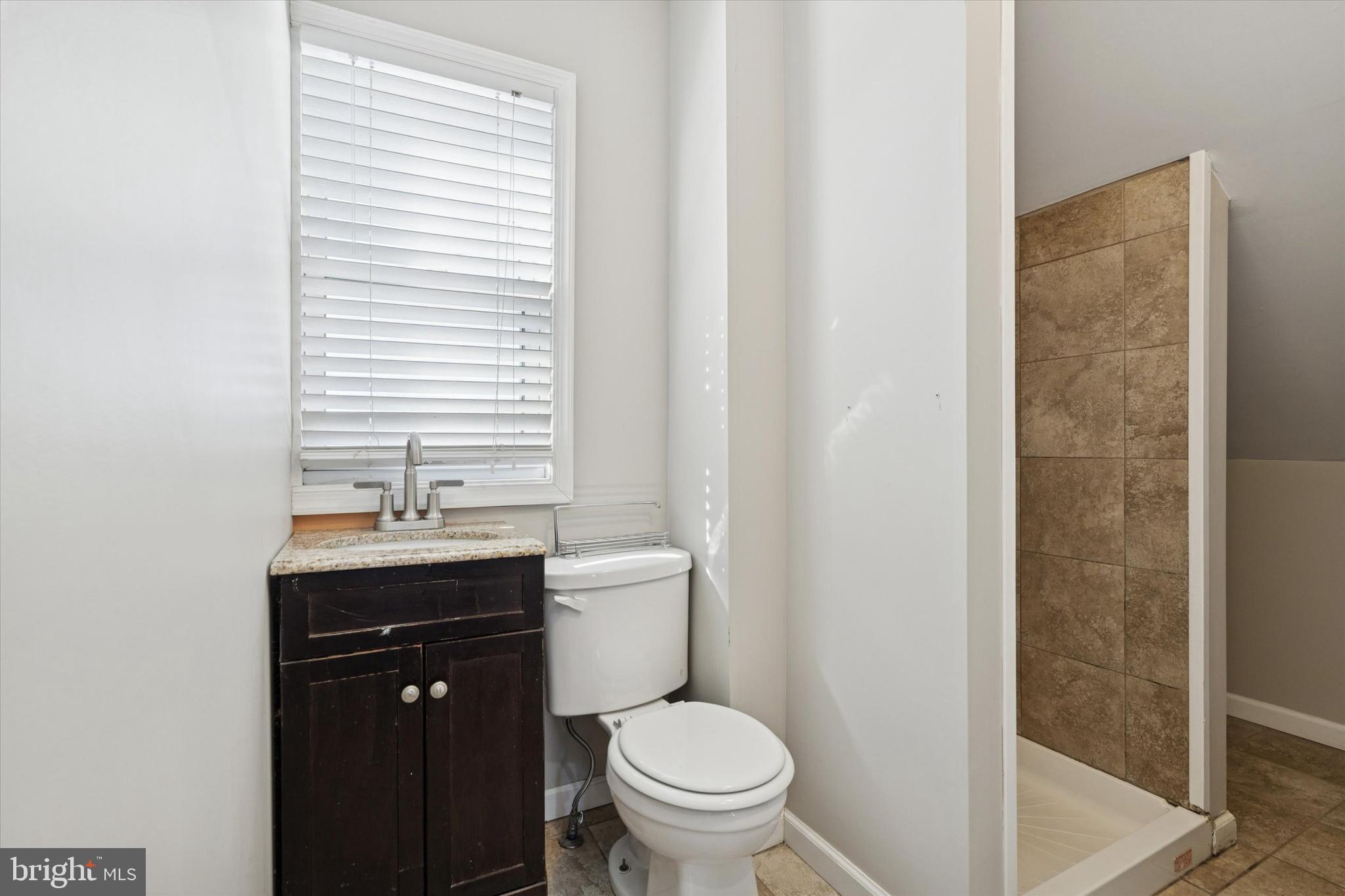 6 Cedar Road Wallingford, PA 19086 - Photo 27 of 36 a bathroom with a granite countertop toilet a sink and a mirror
