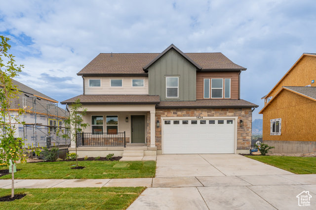 1424 North West Rim Drive, Unit 602 Lehi, UT 84048 - Photo 1 of 1 View of front of property with a garage, a front lawn, and covered porch