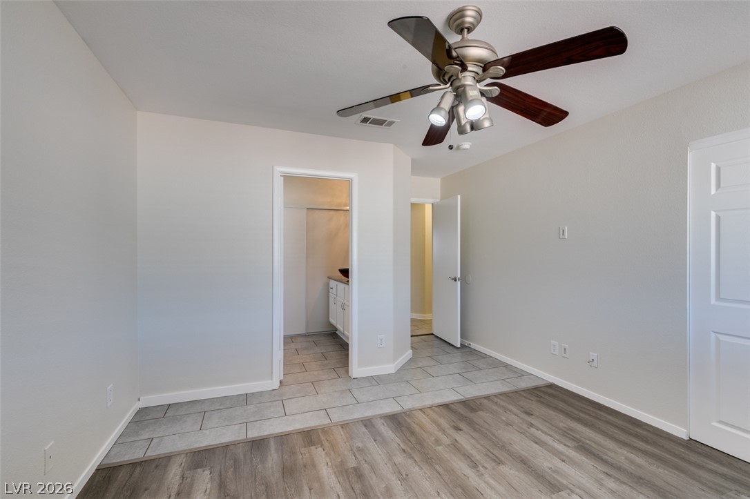 2028 Rustler Ridge Avenue North Las Vegas, NV 89031 - Photo 32 of 40 A versatile room featuring a contemporary ceiling fan and dual flooring textures.