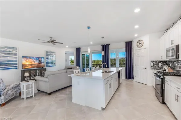 a living room with furniture kitchen view and a window