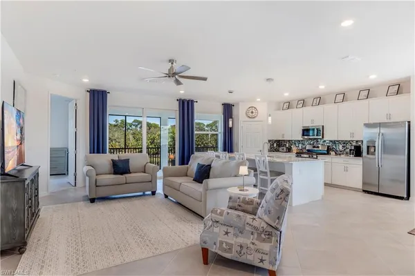 a living room with furniture kitchen view and a refrigerator