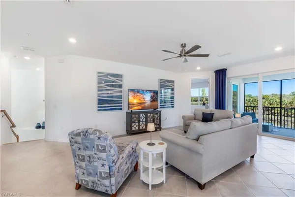 a living room with furniture a flat screen tv and a wall painting