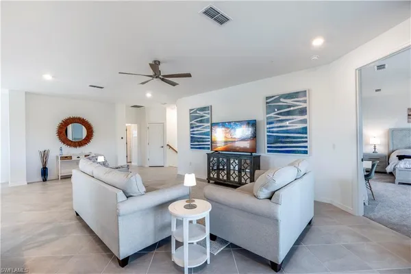 a dining room with chandelier fan and wooden floor