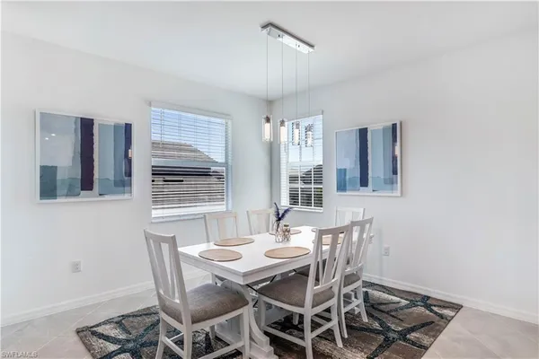 a kitchen with stainless steel appliances a table chairs refrigerator and chairs