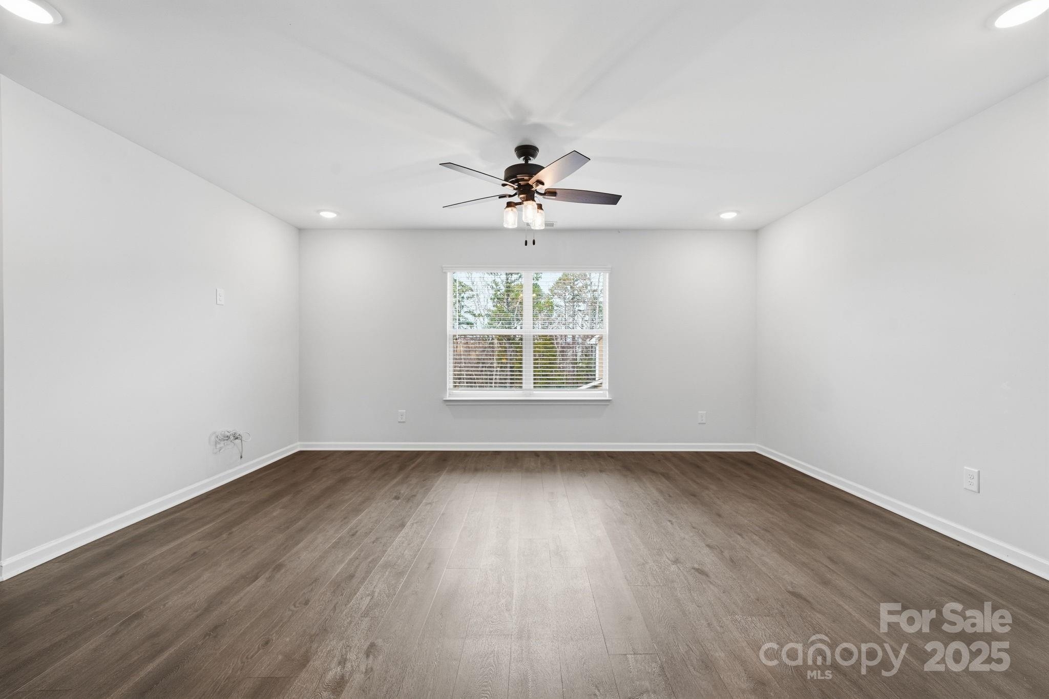 2612 Keady Mill Loop Kannapolis, NC 28081 - Photo 26 of 48 an empty room with wooden floor chandelier fan and windows