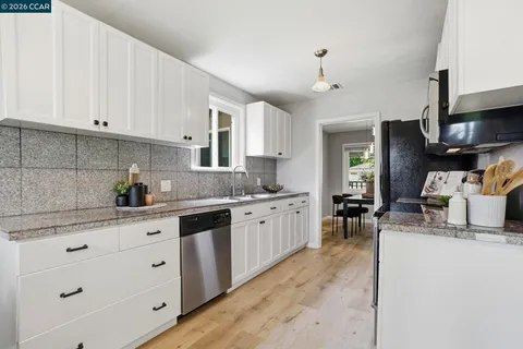 a kitchen with granite countertop a sink stove and cabinets