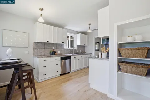 a kitchen with a sink stove and white cabinets