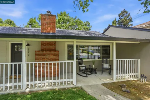 a view of a house with a small yard and wooden fence