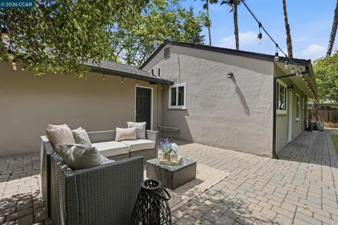 a front view of a house with a garden and trees