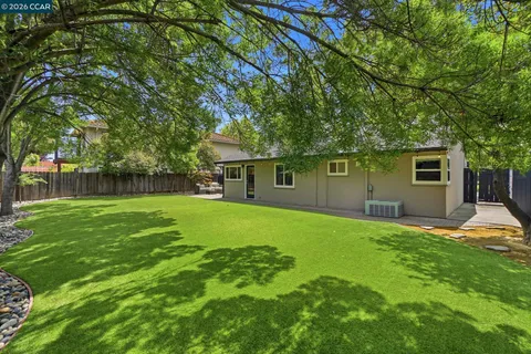 a front view of a house with a garden and trees