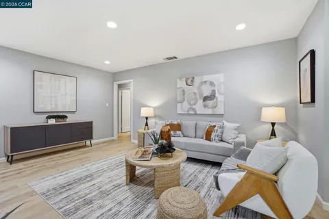 a living room with furniture and a wooden floor