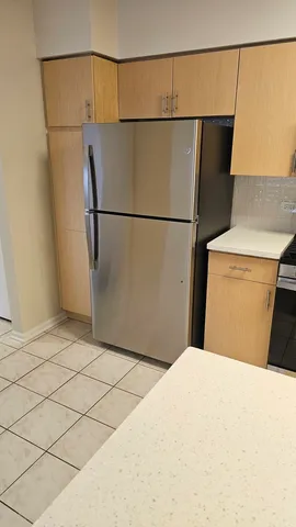 a bedroom with a bed and a refrigerator