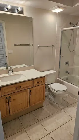 a bathroom with a granite countertop sink a toilet and shower