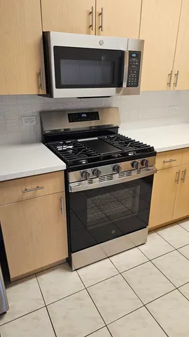 a stove top oven sitting inside of a kitchen