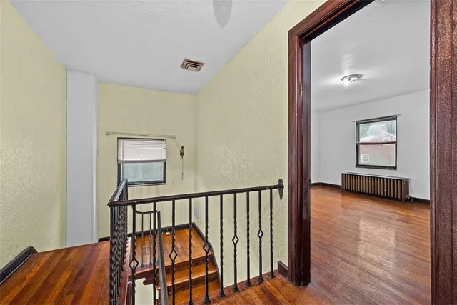a view of a hallway with wooden floor and staircase