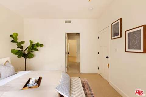 a bedroom with a bed and a potted plant