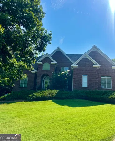 a front view of a house with yard and green space
