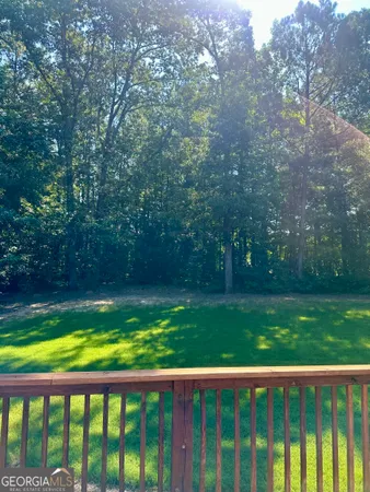 a view of backyard with swimming pool and green space