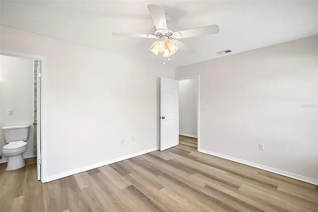 a view of a room with wooden floor and fan
